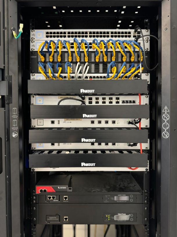 A network server rack filled with organized cables and equipment inside a secured cabinet.